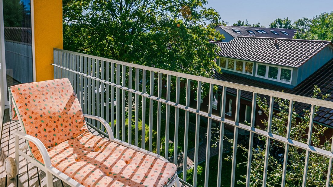 Balcón soleado en la casa del jardín con tumbona